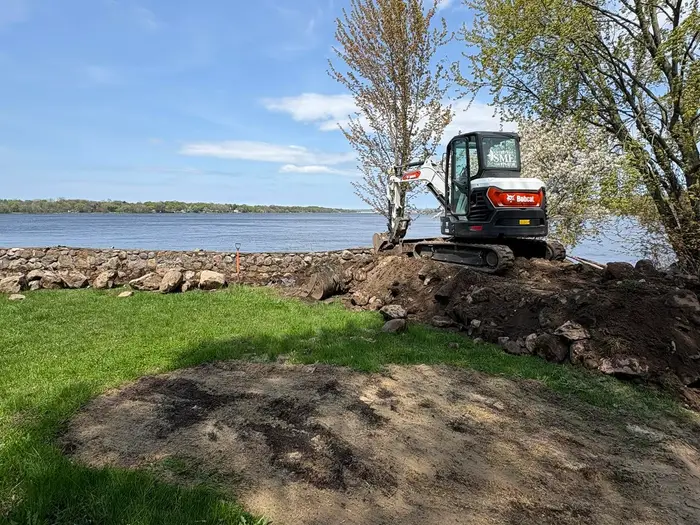Pelle compacte de l'Entreprise SME sur un chantier au bord de l'eau