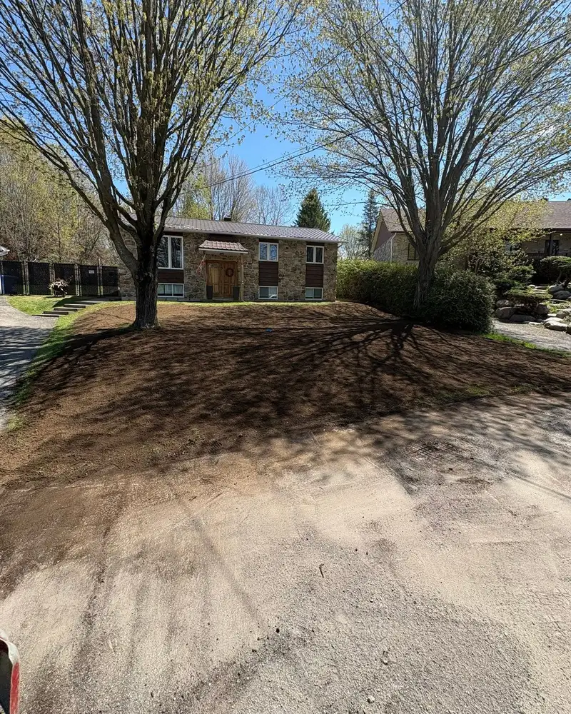 Terre noire fraîchement étendue sur un parterre devant une maison