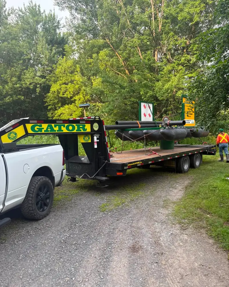 Remorque fardier à col de cygne attelée à une camionnette, chargée pour le transport d'équipement